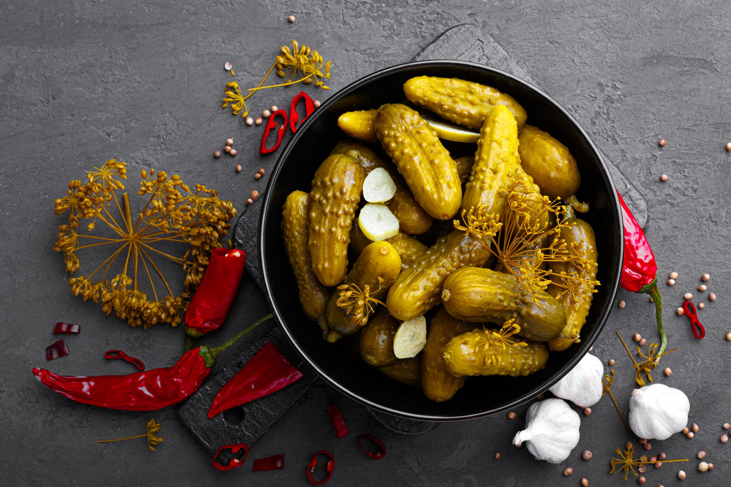 Homemade small preserved cucumbers, fermented, salted or marinated pickles with garlic, chili and dill